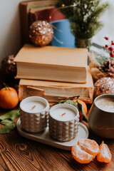 handmade scented candles, coffee, books and tangerines for the New Year. Cozy atmosphere of Christmas at home