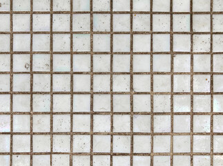 Texture of fine little ceramic tiles background. Mosaic-coated surface with fine square tiles. Texture of fine ceramic tiles close up. White floor tiles