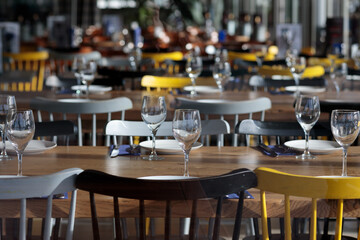 Fototapeta na wymiar Casual restaurant interior with empty glasses and tables with yellow chairs