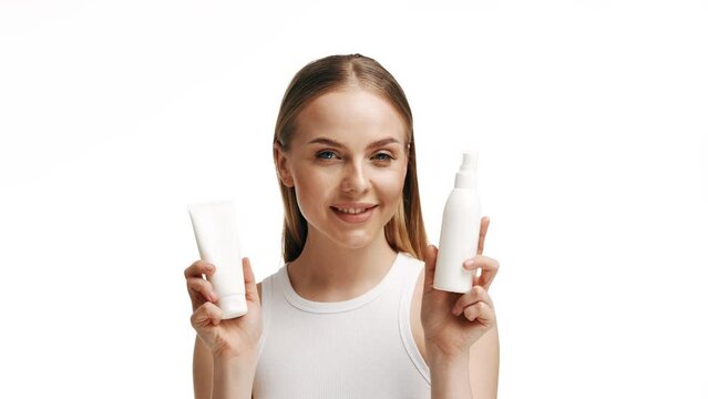 Beautiful blonde girl with a bottle of shampoos in hands. Girl with shiny and long hair. Woman long hair. Woman hold bottle shampoo and conditioner. Woman holding shampoo bottle
