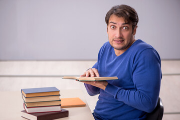 Young male student preparing for exams in the classroom