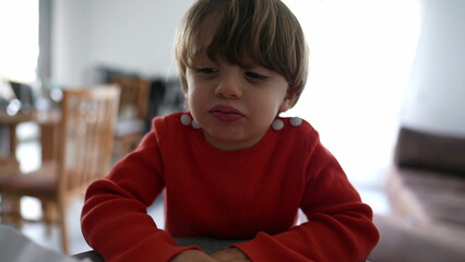 Mischievous little boy spitting to camera. Naughty child not behaving and laughing smiling