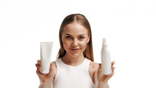 Beautiful blonde girl with a bottle of shampoos in hands. Girl with shiny and long hair. Woman long hair. Woman hold bottle shampoo and conditioner. Woman holding shampoo bottle
