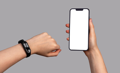 Lodz, Poland February 07 2023 Fitness bracelet on wrist and mobile phone screen mockup in hand. Smartphone display mock up and sport band