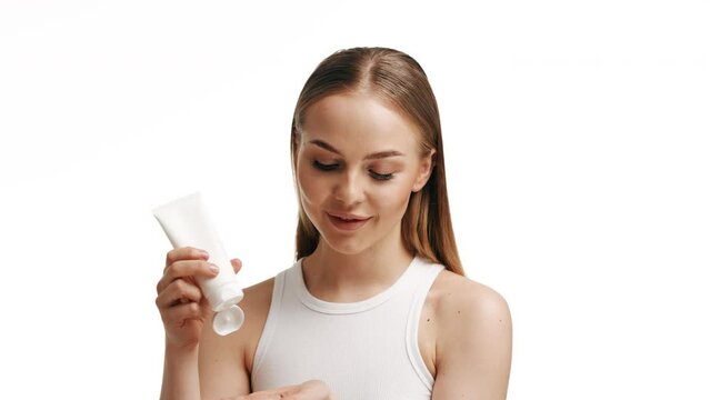 Close Up Beautiful Young Caucasian Blonde Woman With Blue Eyes And Smooth Healthy Skin Holding A Container Of Cream And Using White Cream Skin Care Cosmetic Concept