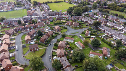 Aerial drone photo of the village of Sharlston and Sharlston Common in Wakefield in the UK, showing the residential housing estates of the village on a sunny day in the summer time.