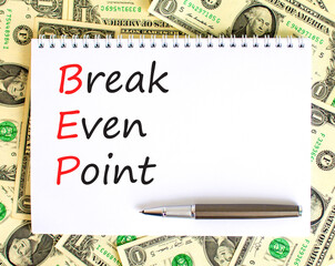 BEP break even point symbol. Concept words BEP break even point on white note on a beautiful background from dollar bills. Pen. Business and BEP break even point concept. Copy space.