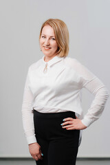 a woman wearing a white shirt and black skirt against a white wall 