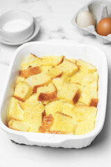 Bread pudding with caramel sauce on top. White background.