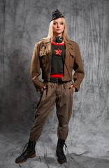 A strict blonde in a military outfit, a Khaki suit with breeches and a cap on her head. A fantastic mixed outfit of a fictional military