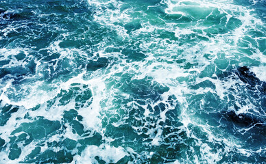 Fototapeta na wymiar Aerial view of the ocean water surface and waves. Beautiful water background texture for tourism and advertising. Tropical coast