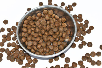 Full dog food on stainless dish on white background. Organic grain food for dog or cat with meat flavour. Animal and pet concept.