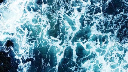 Aerial view of the ocean water surface and waves. Beautiful water background texture for tourism and advertising. Tropical coast