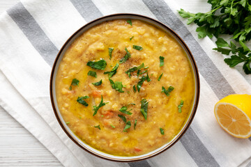 Homemade Lentil Soup with Parsley in a Bowl on a white wooden background, top view. Overhead, from above, flat lay.