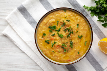 Homemade Lentil Soup with Parsley in a Bowl on a white wooden background, top view. Overhead, from...