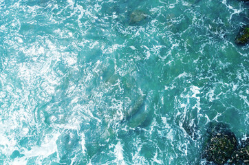 Aerial view of the ocean water surface and waves. Beautiful water background texture for tourism and advertising. Tropical coast