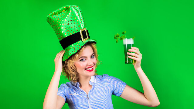Patricks Day pab party. Happy woman in leprechaun hat with green beer. Smiling girl in green hat drinking green beer. Irish tradition. Patricks Day female in top hat with mug of beer. Clover in beer.