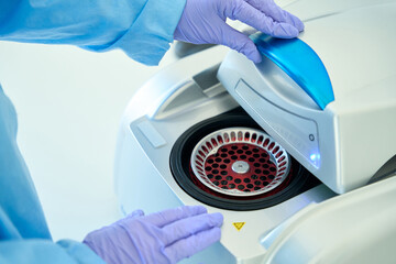 Hematologist laboratory assistant in glove works with hematological centrifuge