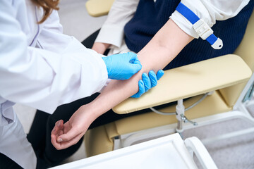 Llaboratory assistant inserts a needle into the patient vein