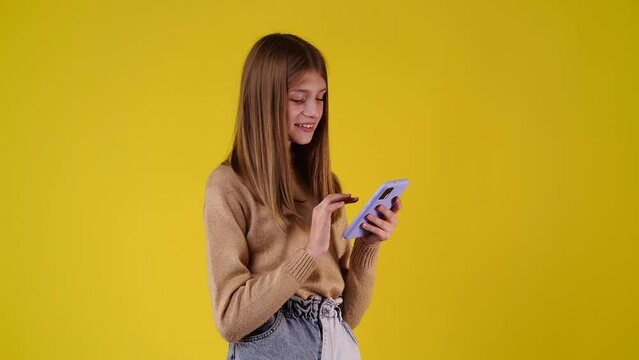 4k svideo of one girl using her phone over yellow background.