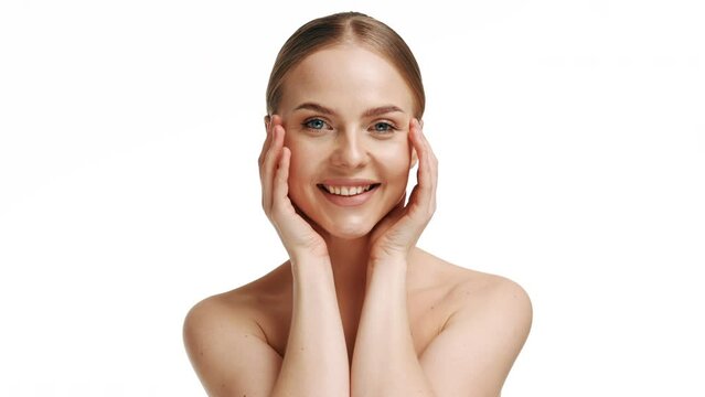 Beauty woman face with blue eyes looking at camera, isolated on white background. Beautiful female model with perfect clean fresh skin. Skin care treatment or cosmetic ads concept.