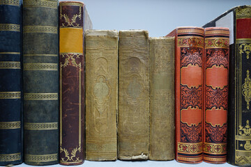 Vintage historical old book with cloth binding lined up on a bookshelf