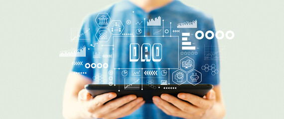 DAO- Decentralized Autonomous Organization theme with young man using a tablet computer