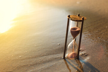 Antique sandglass lost in the sand on the beach. The sands of Time.
