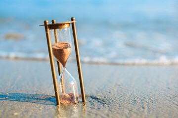 Vintage sandglass lost on the beach. Sands of time.