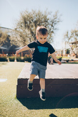 boy jumping off a platform outside with trees