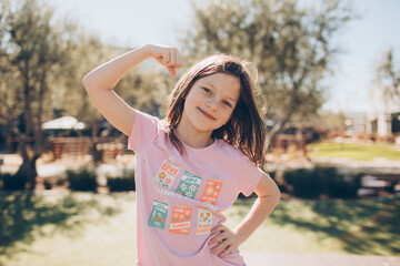 girl in pink showing her muscles