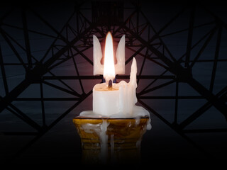 A burning candle melted like the coat of arms of Ukraine symbolizes the fight against destruction...