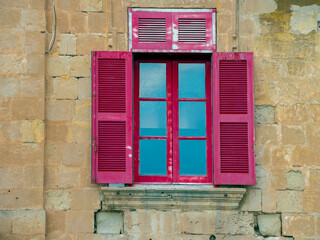 Fragment of the building's facade with traditional wooden ornate balconies painted in Valletta, Malta.
