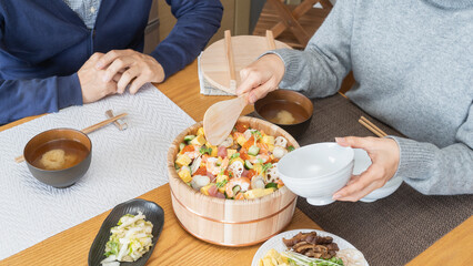 Obraz na płótnie Canvas 日本の料理｜ちらし寿司を食べる男女　イメージ