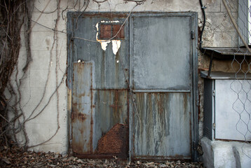 Dirty and rusty bdark gray metallic doors of an abandoned factory or bunker looking like the gates...