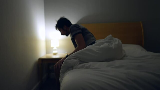 Man waking up in the middle of the night unable to sleep. person suffering from insomnia gets out of bed