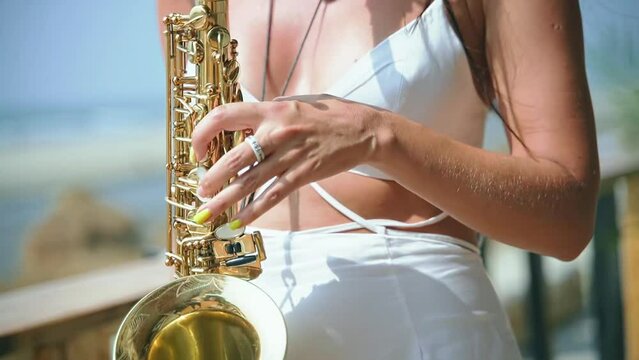 A young woman of charming appearance of European origin plays the saxophone