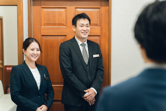 結婚式場・ホテルで働くスーツ姿のコンシェルジュ・ホテルマン・ホテリエ・ウェディングプランナーの男女
