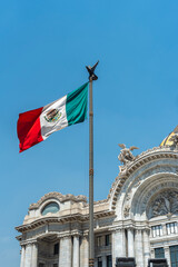 Fototapeta na wymiar Mexican flag waving with blue sky and clouds and the Bellas artes palace in the background in Mexico City - Flag Waving, Mexico Flag - Palacio Bellas artes