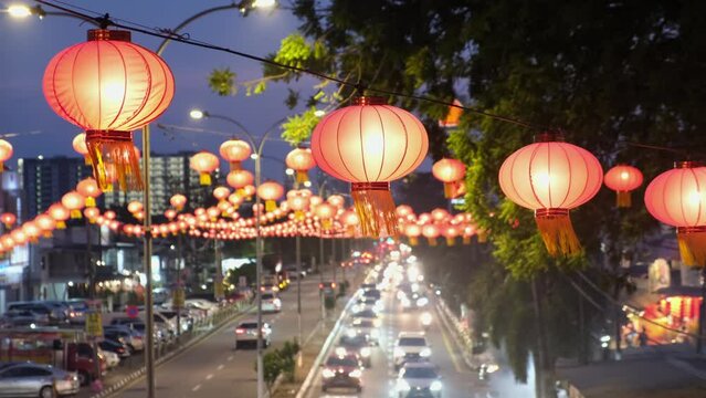 Select focus red Chinese lantern hang in blue hour. Background is busy car traffic Jalan Raja Uda, Penang