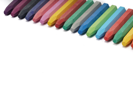 A pile of colorful oil pastels on a white background