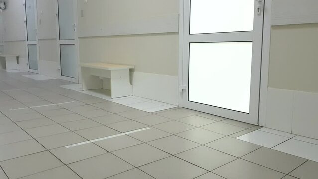 4k video, modern interior of an empty hospital corridor with benches, plastic doors, slow camera movement