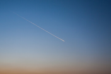 The trace of the plane in the sky, in the clear evening sky