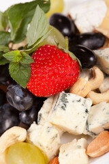 Cheese plate with grapes, nuts and strawberry
