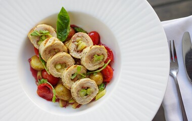 Healthy sliced asparagus stuffed chicken breast roll grilled wrap with cherry tomatoes and potato top view