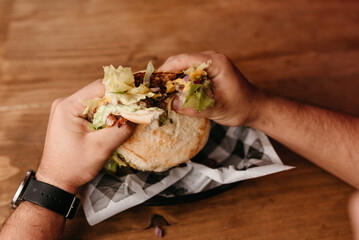 Burger - Man with watch on his wrist holding a hamburger in his hands