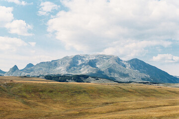 Mountain range rises above a valley against a blue sky
