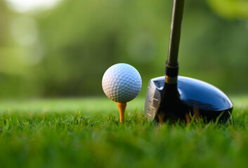 Close-up golf ball on tee with golf drivers at golf course. - obrazy, fototapety, plakaty