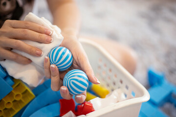 Hands cleaning with alchohol to disinfecting toys.