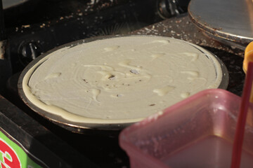 process of cooking pancake crepes at street food center